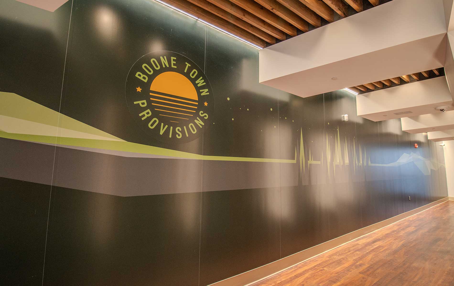 Green feature wall with boone town provision logo