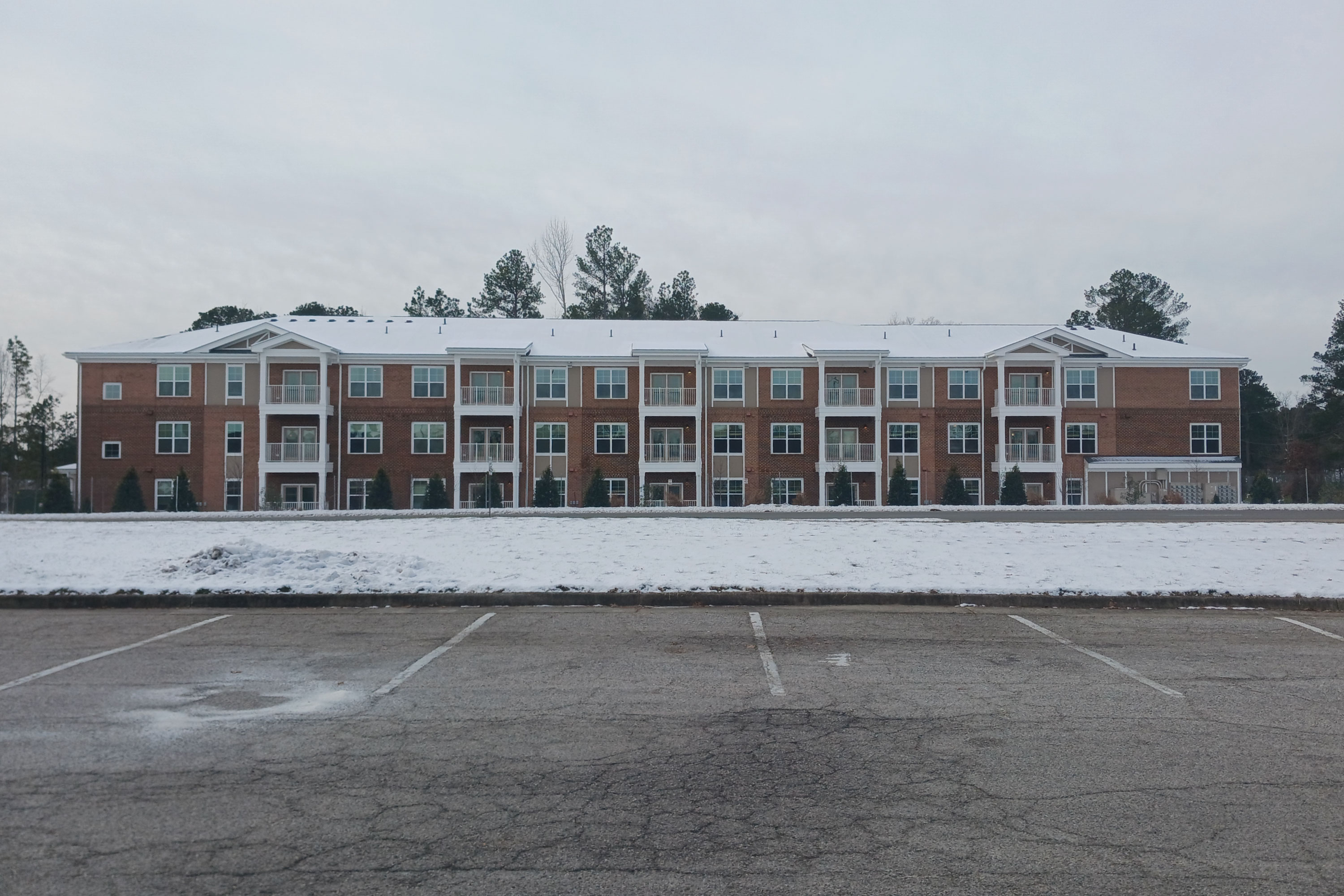 Exterior brick apartment building covered in snow.